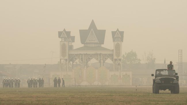 Prajurit TNI melakukan latihan di tengah kabut asap yang menyelimuti kawasan Stadion Sanaman Mantikei di Palangkaraya, Kalimantan Tengah, Jumat (2/10). (ANTARA/Rosa Panggabean) Enam Bulan, Kabut Asap Masih Kepung Sumatra-Kalimantan